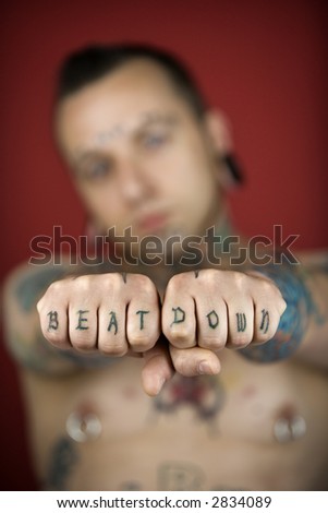 stock photo Caucasian midadult man with tattoos and piercings holding out