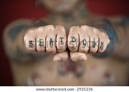 stock photo : Caucasian mid-adult man with tattoos and piercings holding out 