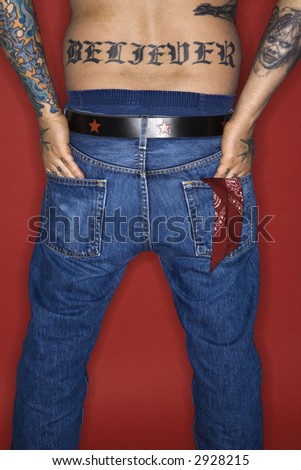 stock photo Caucasian midadult man back view with tattoo reading believer 