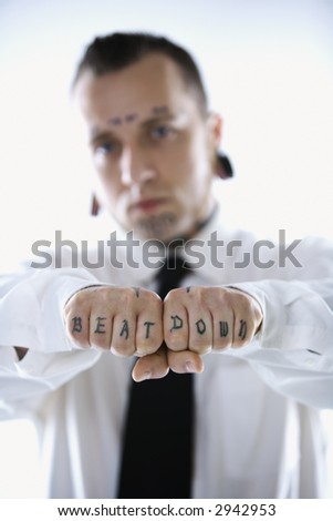 stock photo Caucasian midadult man with tattoos and piercings holding out