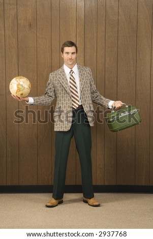 Mid-adult Caucasian male in retro suit holding luggage and a globe.