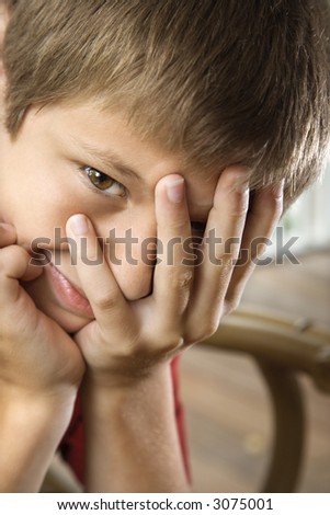 stock photo Portrait of Caucasian preteen boy with hand partially over 