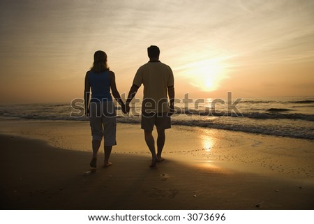 Two People Holding Hands In The Sunset. walking holding hands on