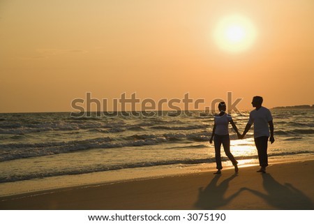 couple holding hands in sunset. couple holding hands and