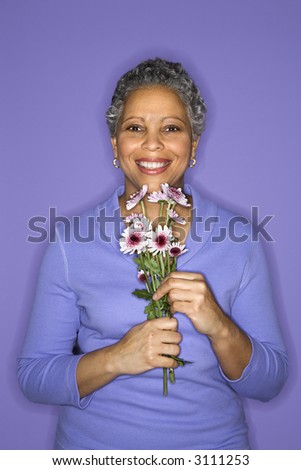 stock photo : African American mature adult female holding flowers. stock photo : African American mature adult female holding flowers.