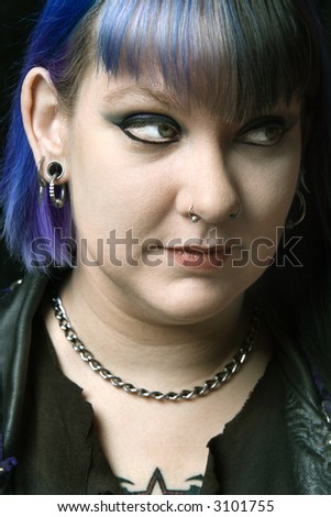 Head shot of Caucasian woman with blue hair looking off to side.