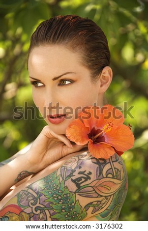 stock photo Attractive Caucasian tattooed woman with Hibiscus flower over 