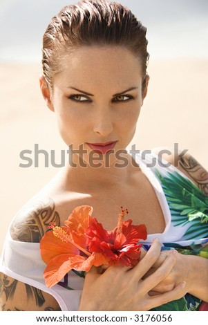 stock photo Attractive Caucasian tattooed woman holding Hibiscus flowers