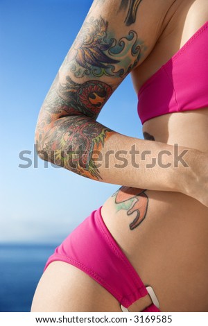 stock photo Tattooed woman in hot pink bikini with Pacific Ocean in 