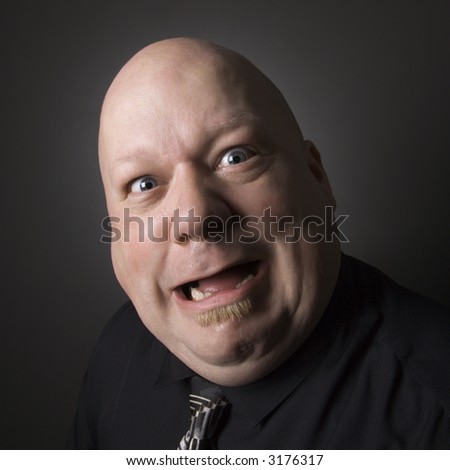 Caucasian mid adult bald man looking at viewer and making facial expression.