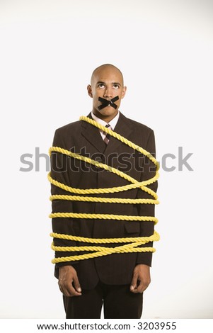 African American businessman wrapped in yellow rope with tape over  his mouth.