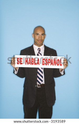 African American man holding sign reading se against blue background.