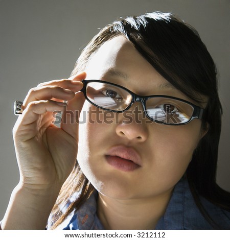 Head and shoulder portrait of pretty young Asian woman wearing eyeglasses.