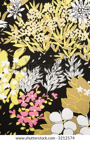Close-up of vintage fabric with pattern of pink and golden flowers and leaves on polyester.