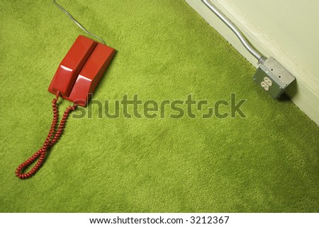 Red vintage telephone on 70\'s green carpet.