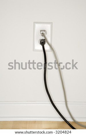 Two cords plugged into electrical wall outlet.