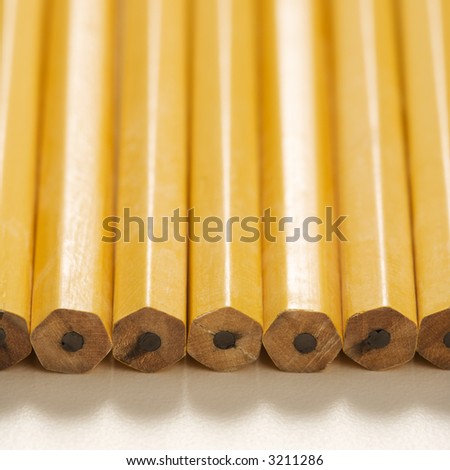 Close up of group of new unsharpened pencils lined up in an even row.