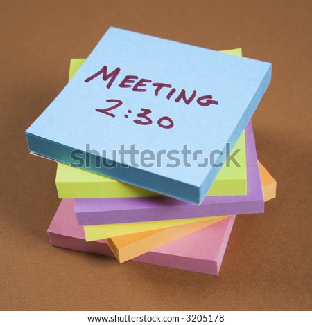 Stack of sticky notes with a meeting reminder.