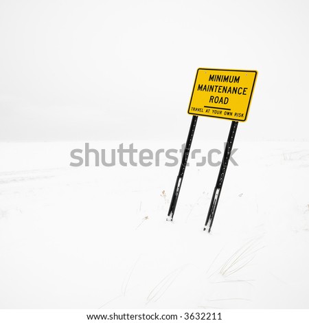 Minimum maintenance road sign in deserted winter blizzard.