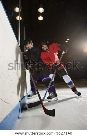 Women hockey players fighting for puck making contact.