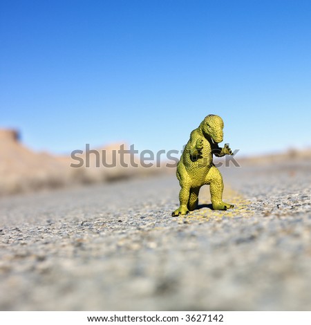 Toy dinosaur in middle of road.