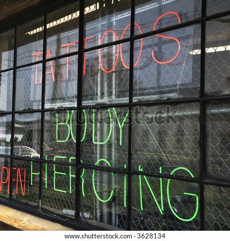 Neon sign in window for tattoos and