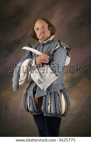 William Shakespeare in period clothing holding feather pen and looking at viewer.