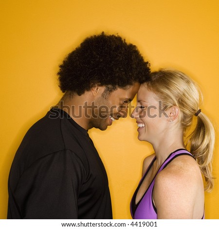 Caucasian woman with head against African-American male\'s head.