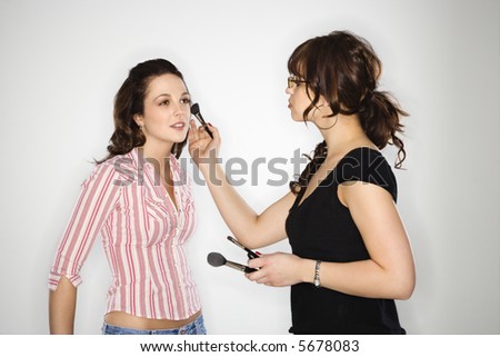 stock photo : Makeup artist putting makeup on young Caucasian woman.