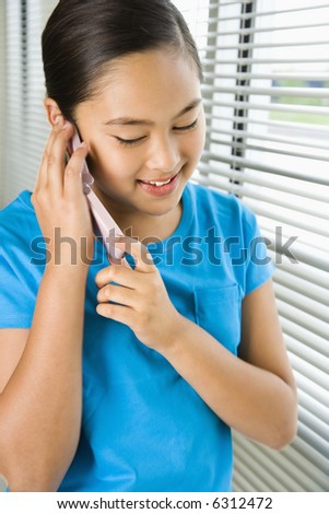 stock photo Asian preteen girl talking on cell phone