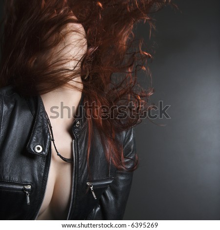Pretty redhead young woman flipping head back with long hair flying out.