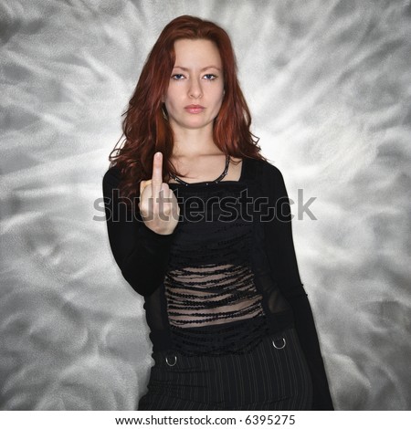 Portrait of pretty young redhead woman giving middle finger gesture.