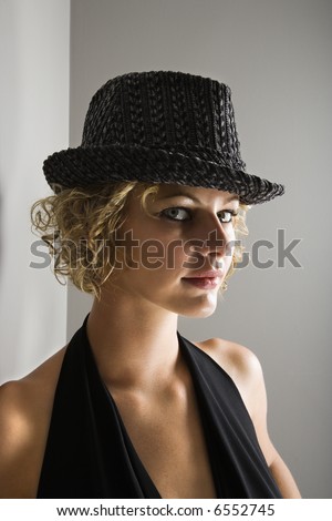 Caucasian young adult woman wearing fedora hat looking at viewer.