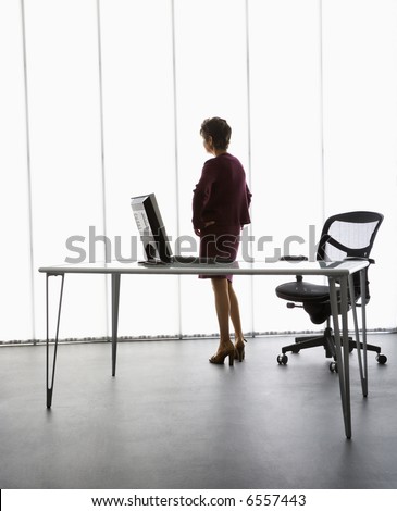 Caucasian middle aged businesswoman standing in office.