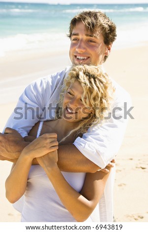 Happy couple embracing on Maui, Hawaii beach.