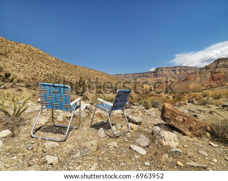 Empty plaid lawn chairs in desert landscape.
