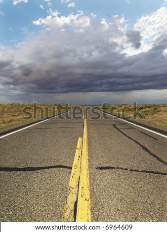 Empty two lane highway leading to desert horizon.