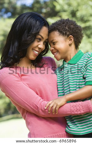 Mother and son with arms around eachother looking at eachother and smiling.