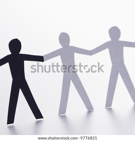 stock photo : Black and white cutout paper people holding hands.