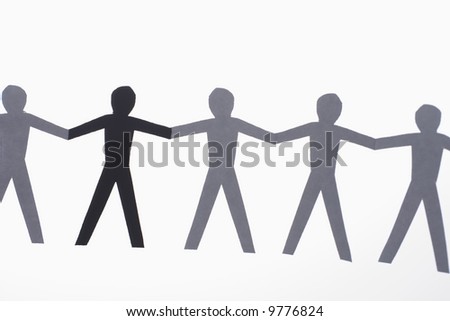stock photo : One black cutout paper person holding hands with group of 