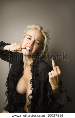 stock photo Caucasian nude woman biting on string and showing middle