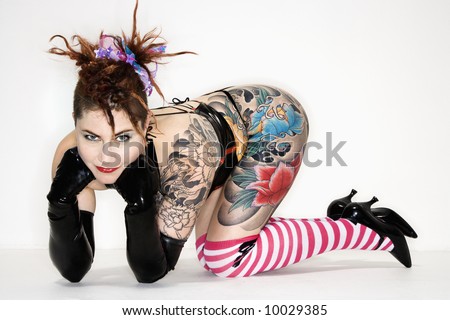 stock photo : Adult caucasian woman with tattoos leaning on floor.