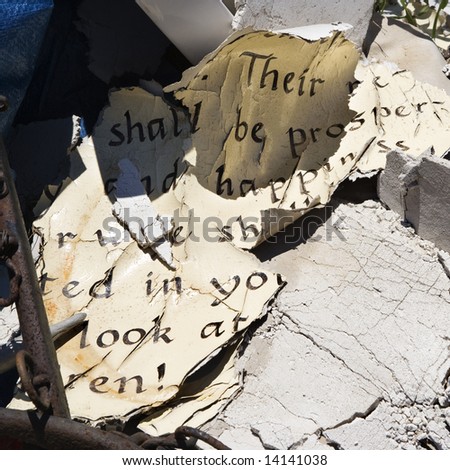 Pages of old weathered bible verse lying in junkyard.