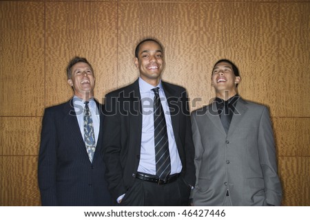 Businessmen of ethnic diversity standing together smiling and laughing. Horizontal shot.