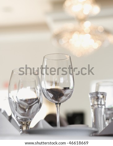 Water and wine glasses on an elegant restaurant dining table. Vertical shot.