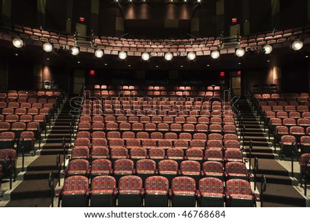 Rows of empty seats in theater seen from stage. Horizontal shot.