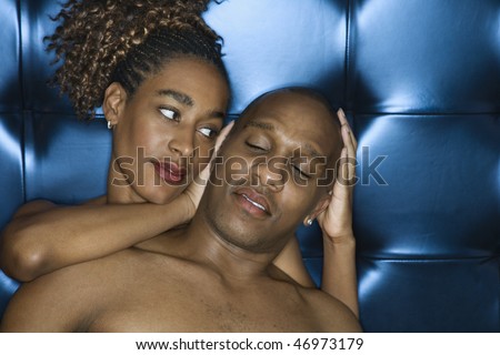 Attractive young shirtless couple sharing a tender moment. The woman is cradling the man\'s head in her hands. Horizontal shot.