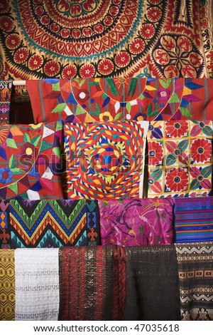Colorful Mexican patterned fabric hanging on a rack. Vertical shot.