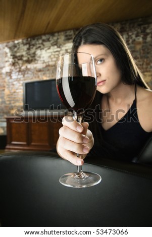 Pretty young Caucasian woman toasting wine glass.