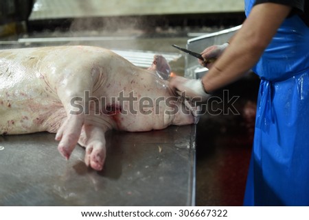 worker cleans pork in meat production